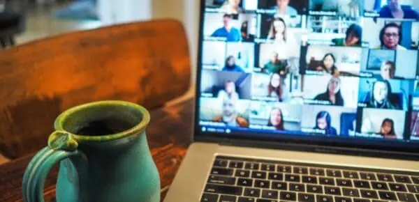 macbook pro displaying group of people for an article about the benefits of conference call transcription