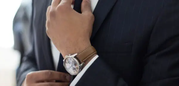 man wearing watch with black suit for feature on how to pick a transcription service provider