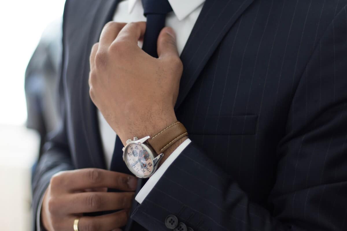 man wearing watch with black suit for feature on how to pick a transcription service provider