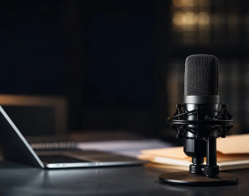 Insurance transcription microphone and laptop representing AI voice fraud and recorded claim documentation
