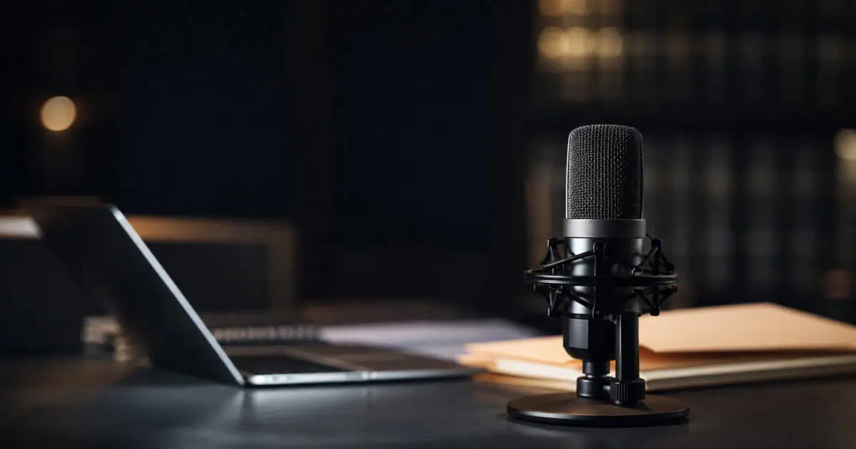 Insurance transcription microphone and laptop representing AI voice fraud and recorded claim documentation
